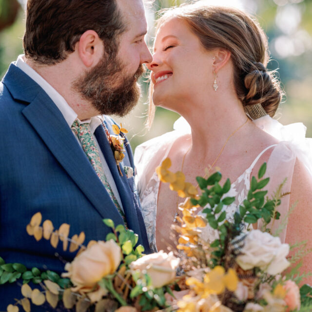 A bride and groom kissing in front of palm trees.