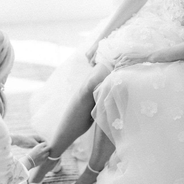 A bride putting on her wedding shoes.